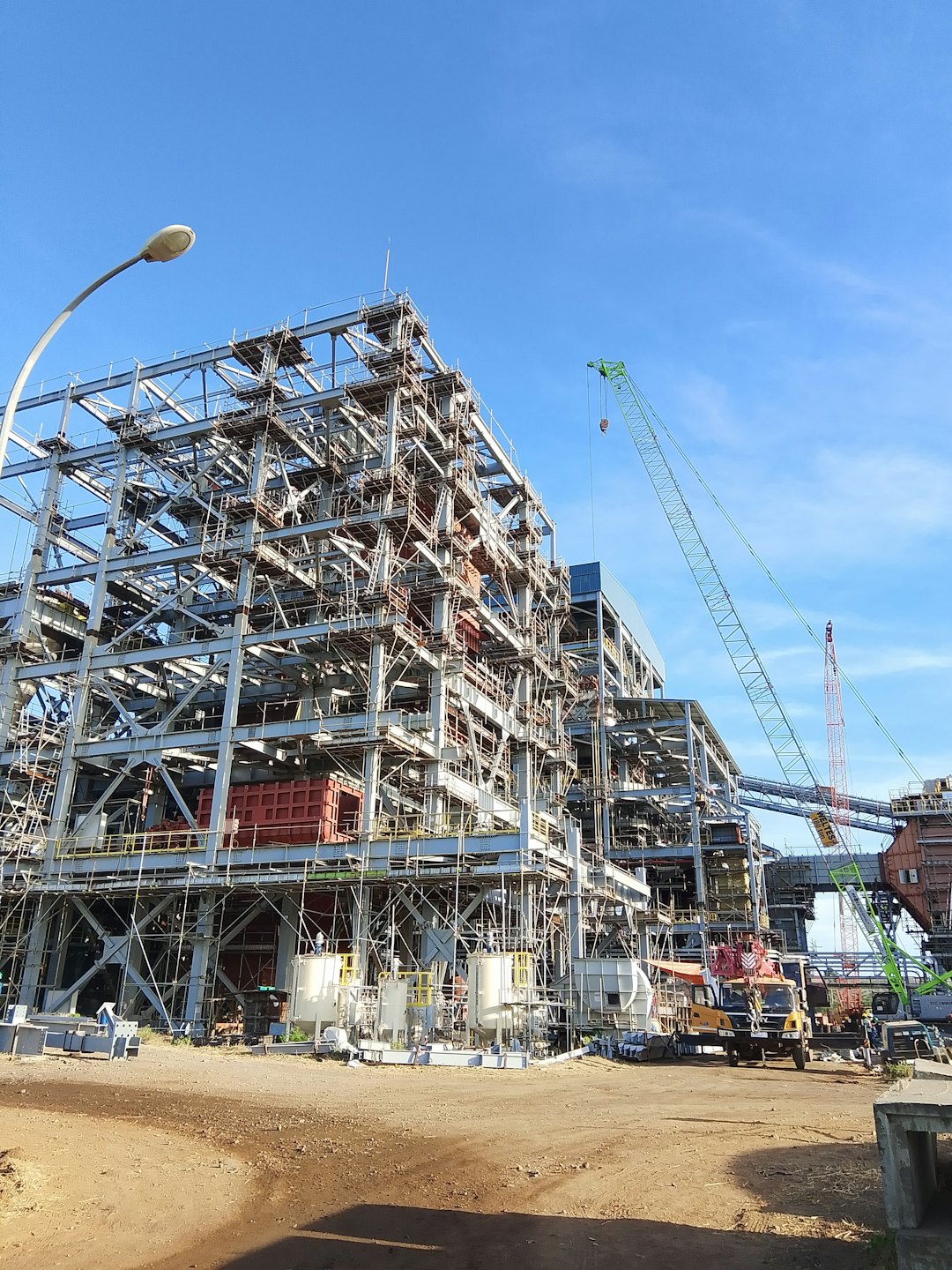 Operai edili costruiscono un'ampia struttura in acciaio in cantiere.